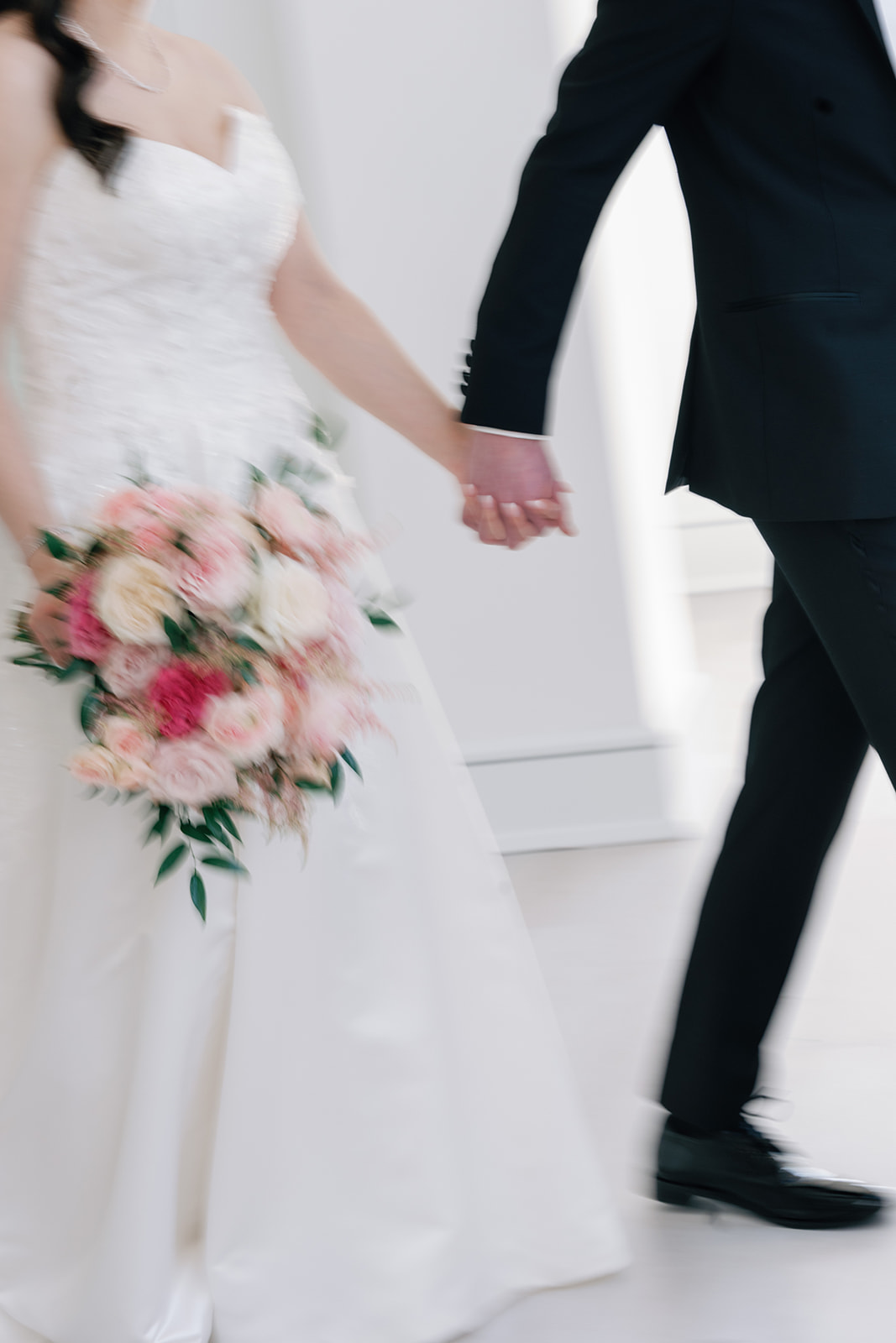 bride and groom holding hands with bouquet