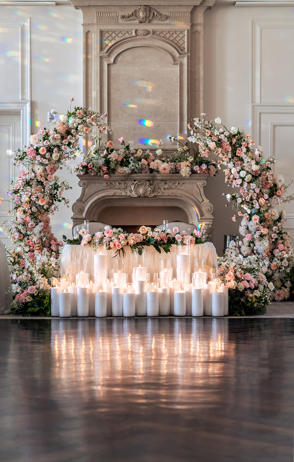 sweetheart table at wedding with floral arch in pink