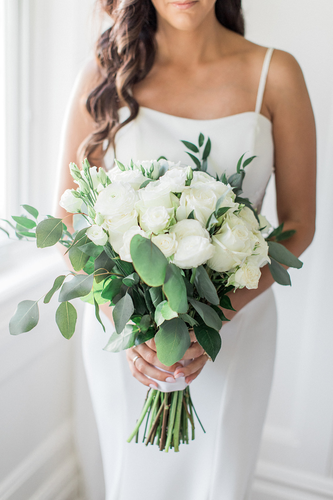 bride holding bouquet of white and green flowers