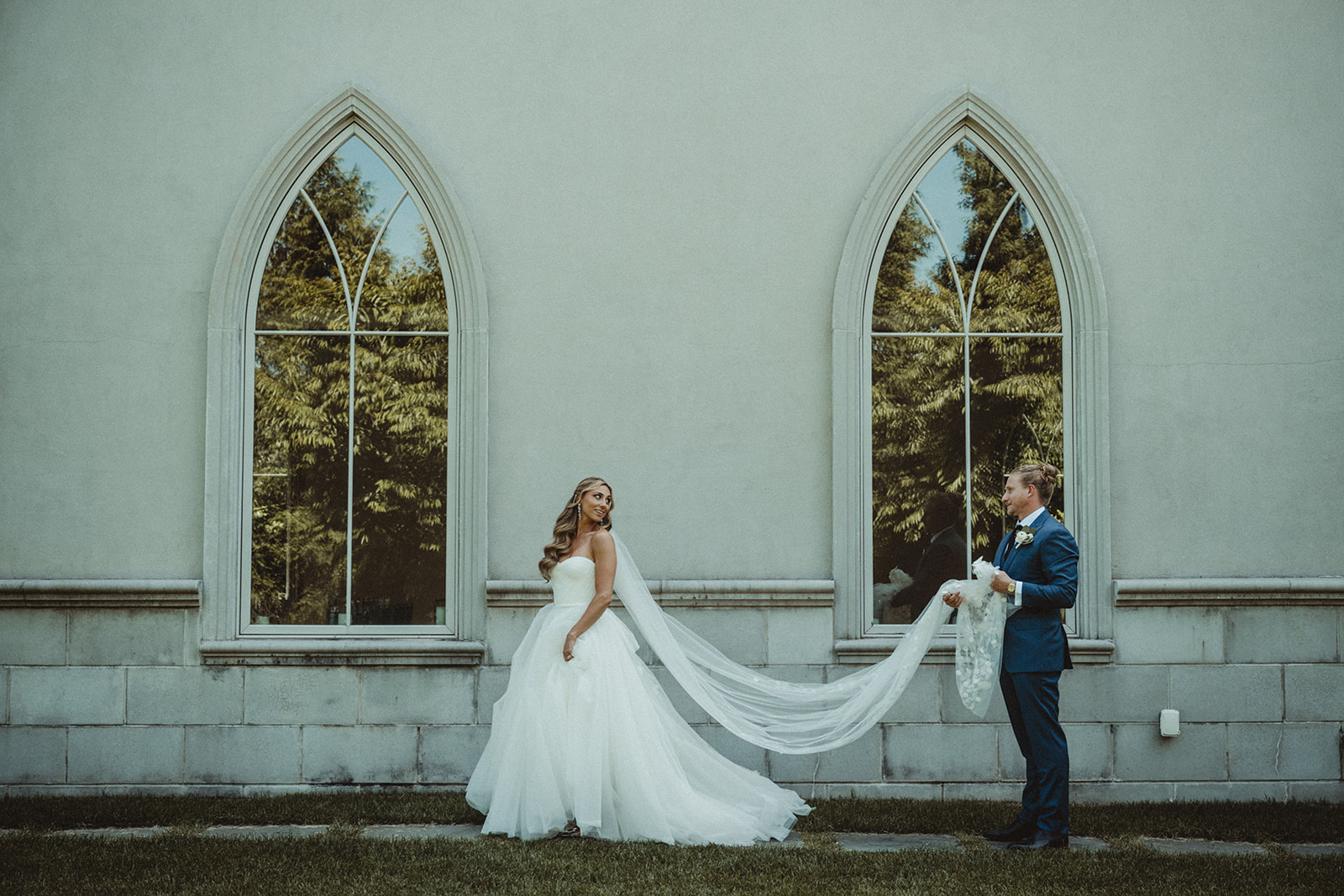 groom holding brides veil