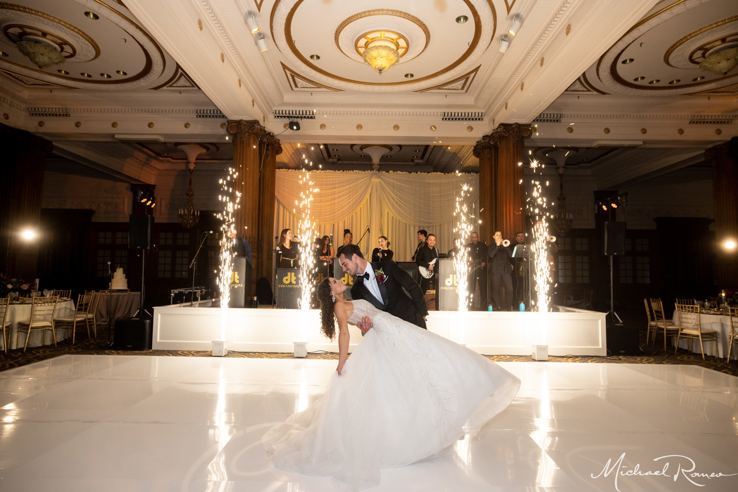 groom dipping bride during wedding reception with sparklers