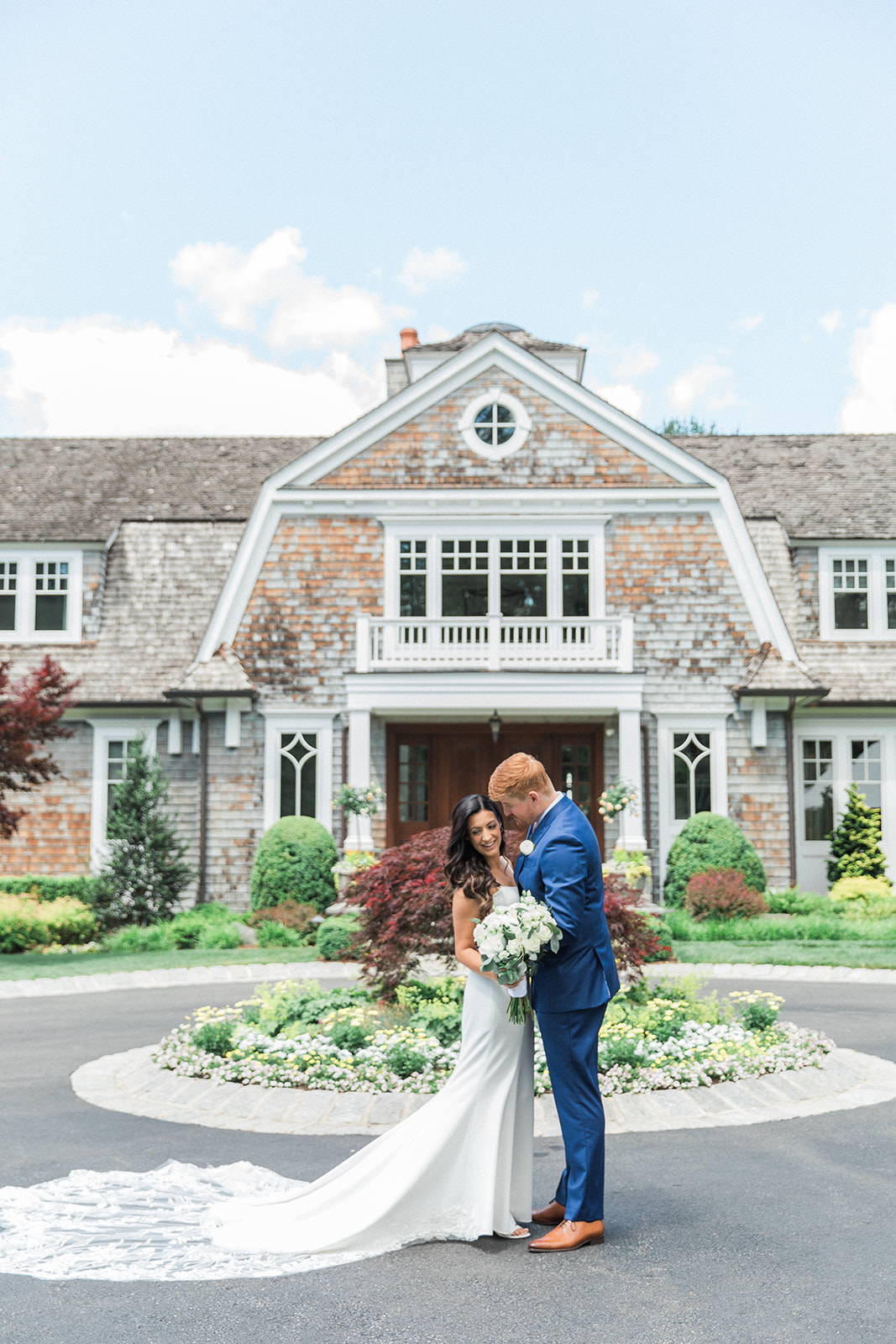 bride and groom kissing in front of home