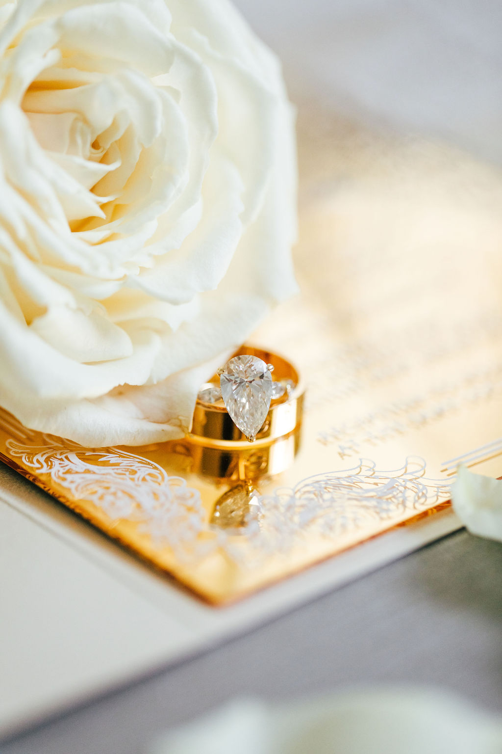 gold engagement ring with gold invitation