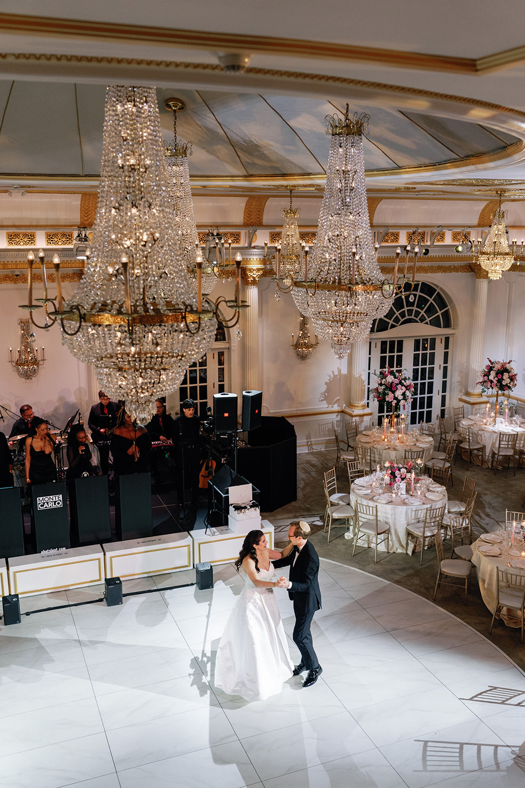bride and groom from above in ballroom with chandeliers