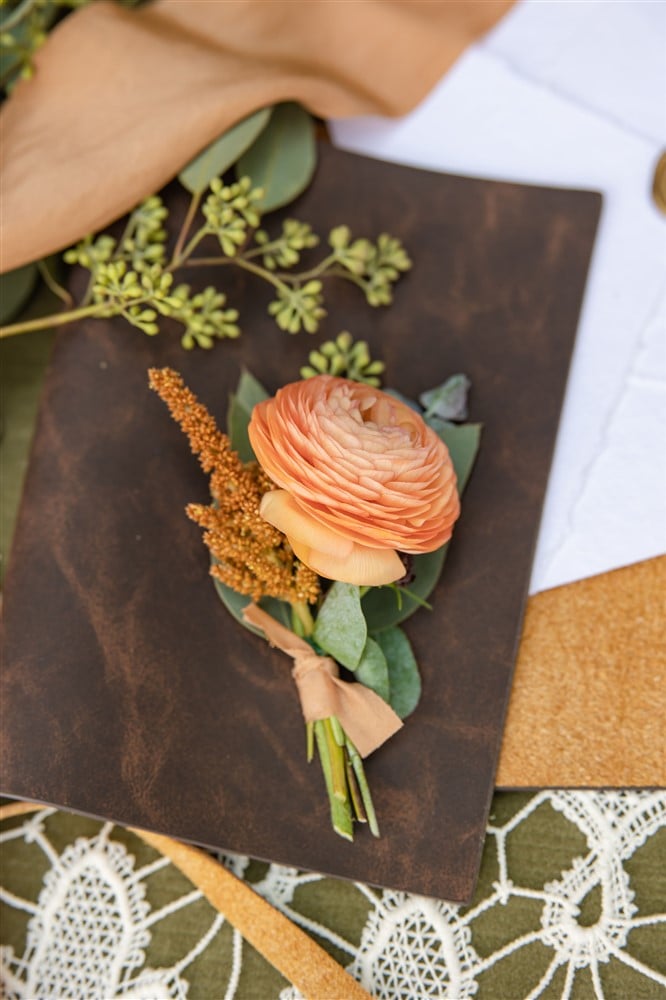 orange flower on invitation in brown leather