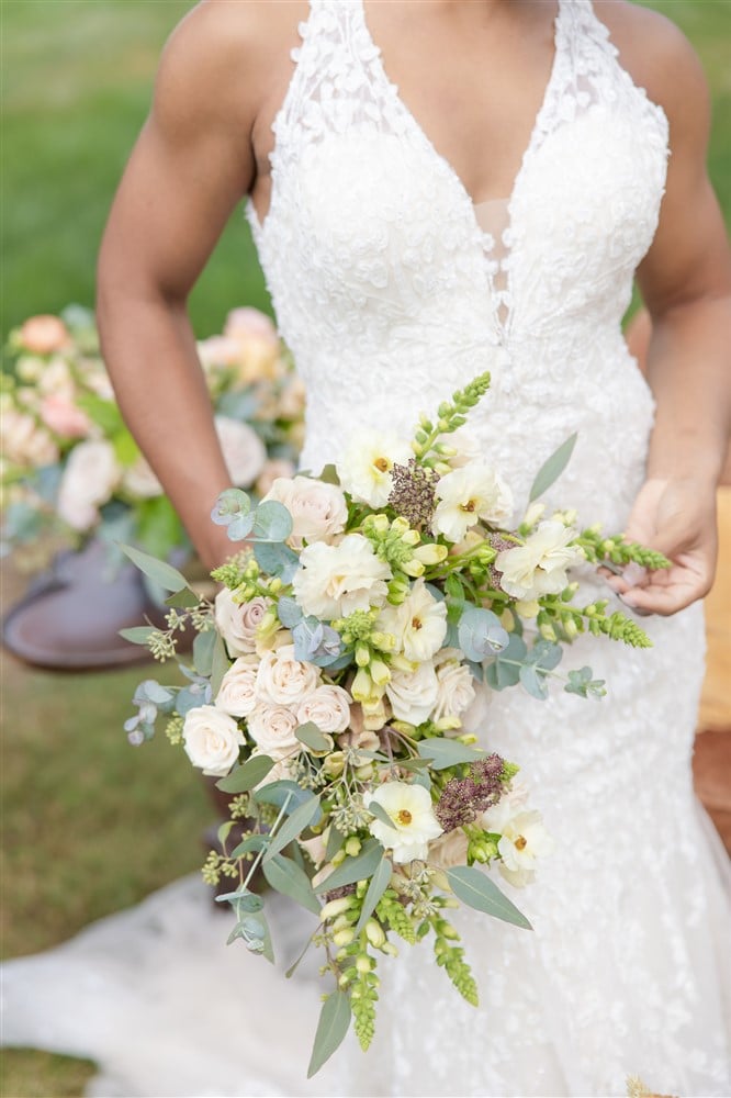 bride holding brown green and white bouquet