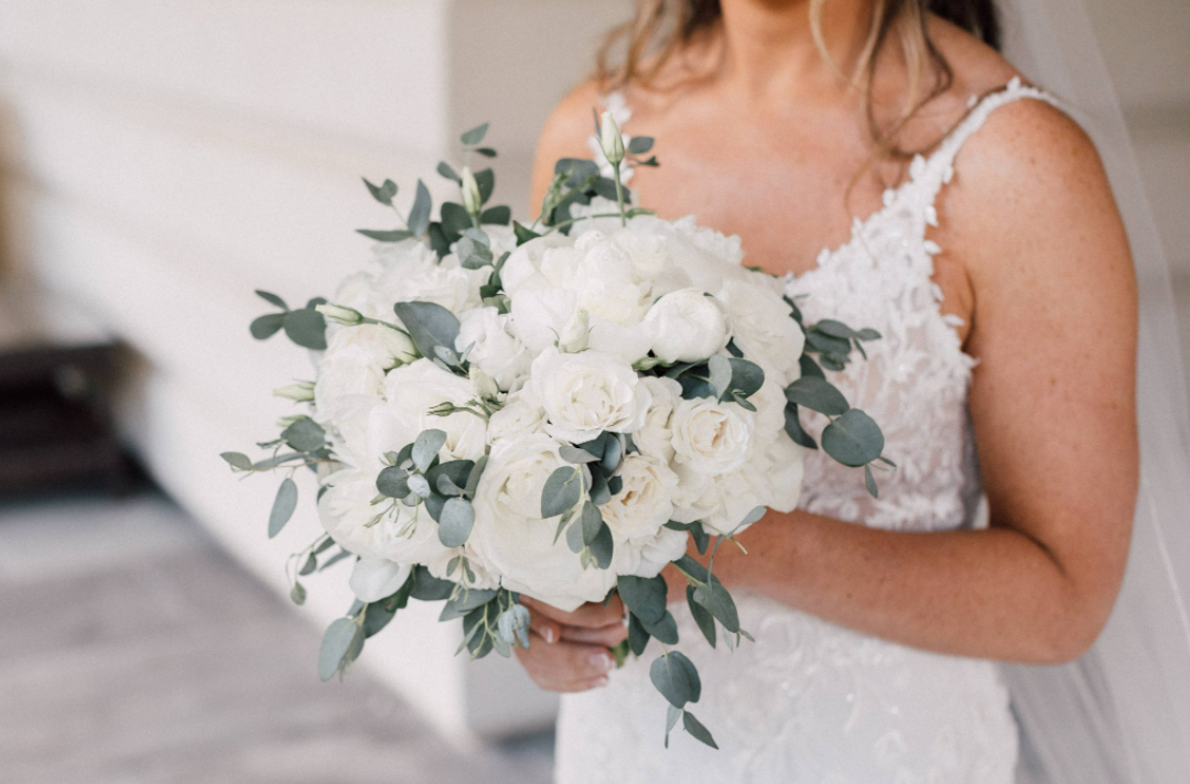 bride holding white and green bouquet